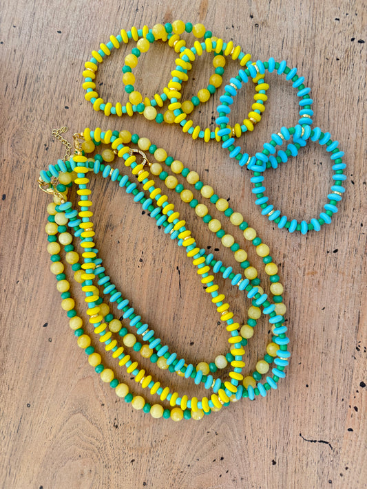 Three colorful beaded necklaces on a wooden surface
