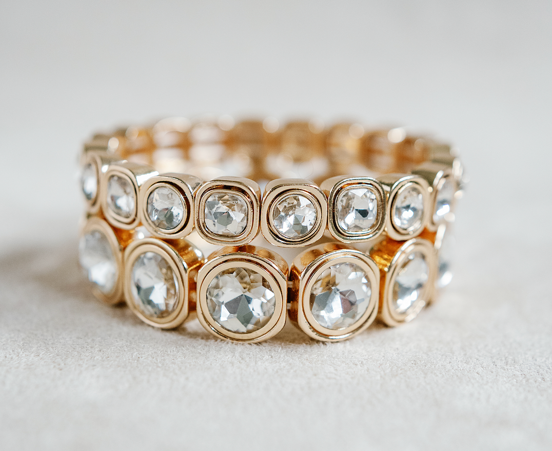 A gold-toned bracelet with circular crystal accents, each housed in rounded square frames, arranged symmetrically around the band for a reflective effect. Gold Bracelet stack