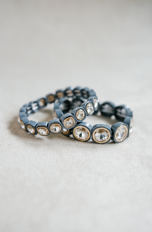 A light gray bracelet featuring large, faceted gemstones framed in gold settings, arranged in a circular, stretchy design ideal for a snug fit. Petite and Round bracelet stack.