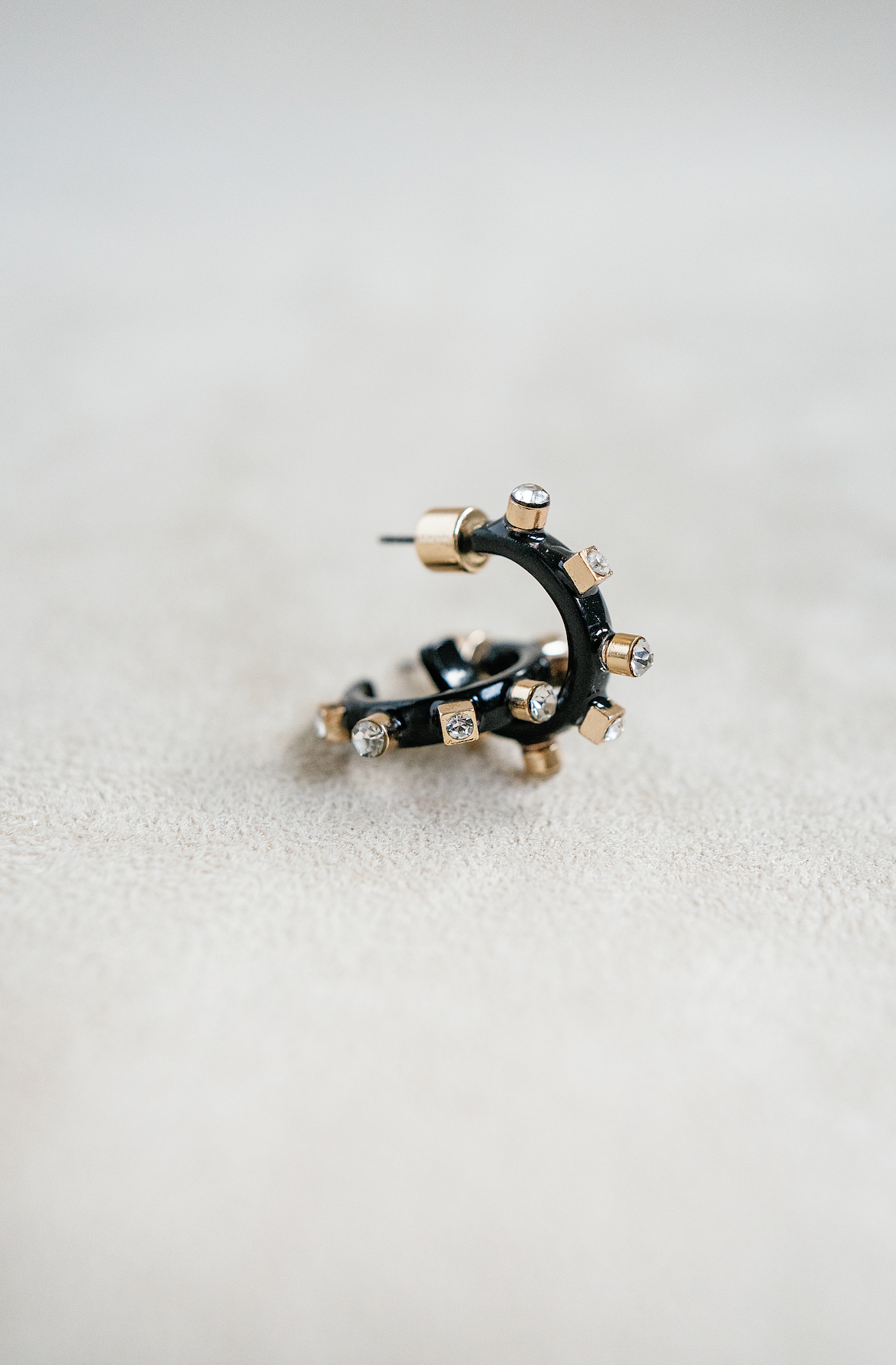 half inch metal huggie mini hoop earring. black huggie hoop with rhinestones.