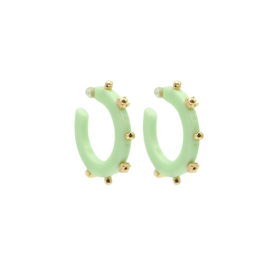 Small pale green open hoop earrings with gold-tone square and round studs along the edge, featuring a sleek, lightweight design and clear post backings.