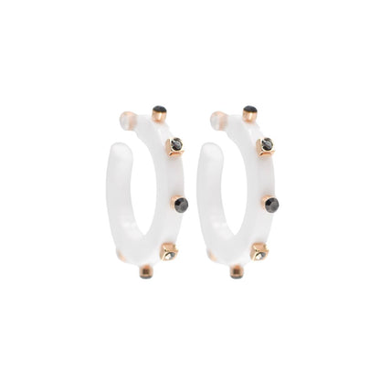 Small white open hoop earrings with gold-tone accents and black crystal studs along the edge, featuring a modern design and clear post backings.