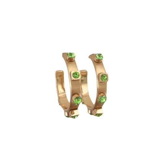 A pair of gold brushed metal hoop earrings with gold studs and green jewel accents, set against a white background to highlight their reflective surfaces.