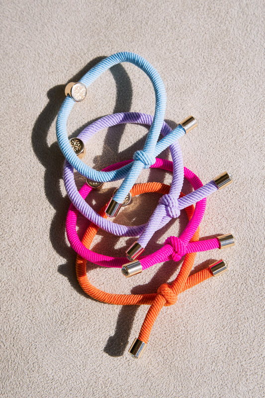 Set of four thick elastic hair ties in vibrant tones, featuring gold metal accents and a knotted design, perfect for durable and stylish hair styling.