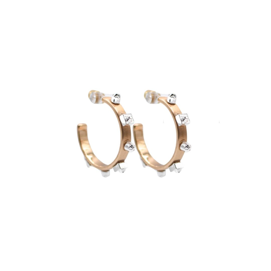 A pair of  gold hoop earrings with matte silver studs, set against a white background to highlight their reflective surfaces.