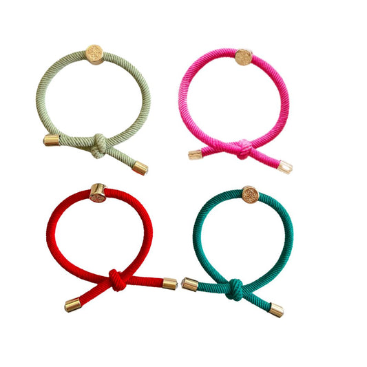 The Christmas Party Hair Tie Set has knotted detail and gold end caps with a jewel center stone. Sold as a set of 4 in shades fern green , red, harbor blue and hot pink.