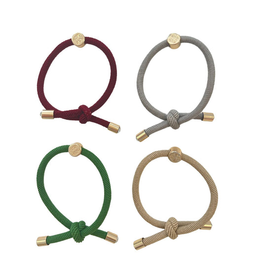 The Christmas Hair Tie Set Comes in a set of 4 in shades of cranberry, light grey, christmas green , and tan 