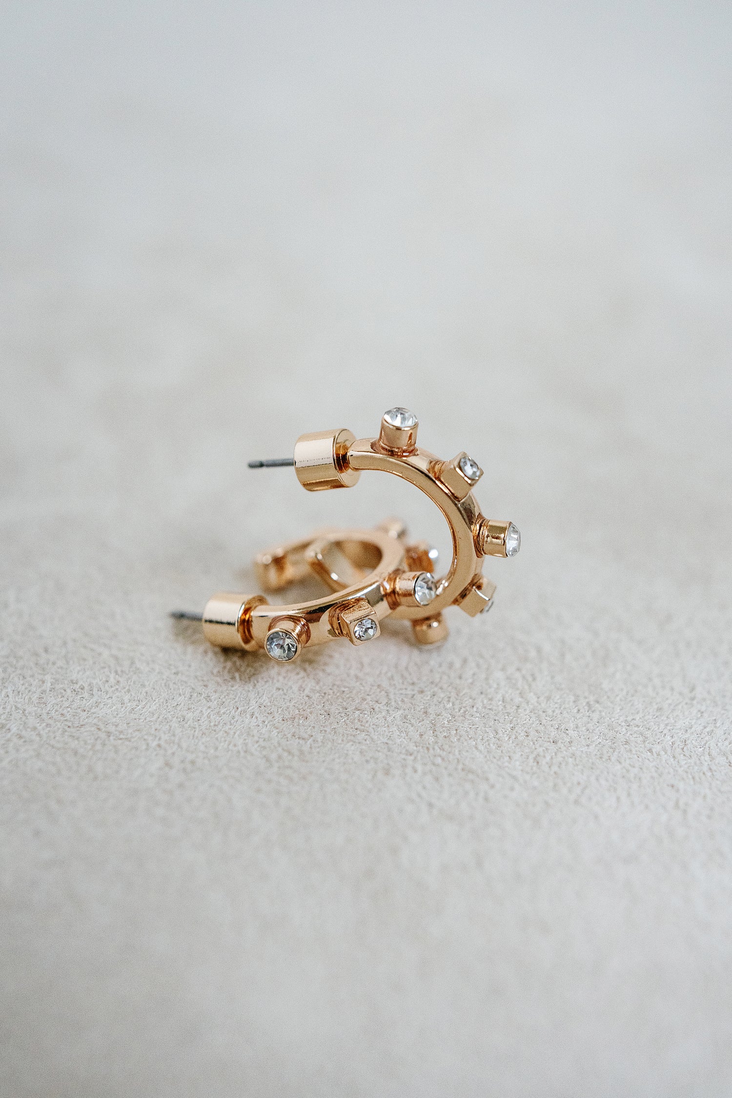 1/2 inch style huggie hoop with gold finish and crystal detil