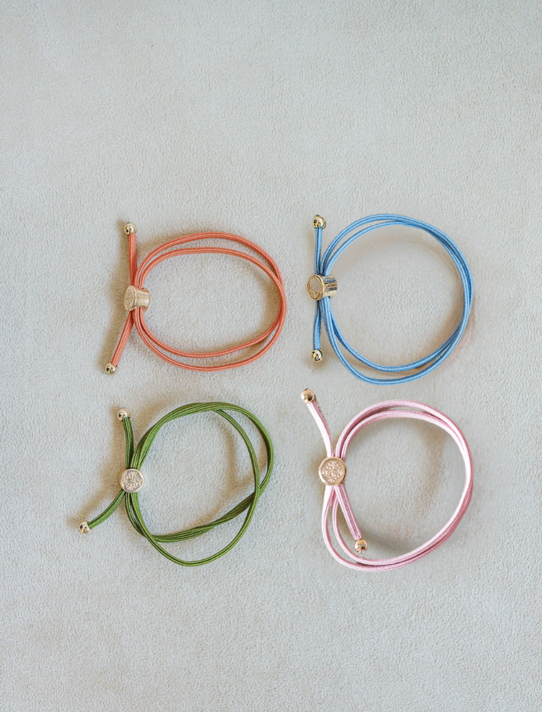 Four colorful bracelets hair tie on a light gray background