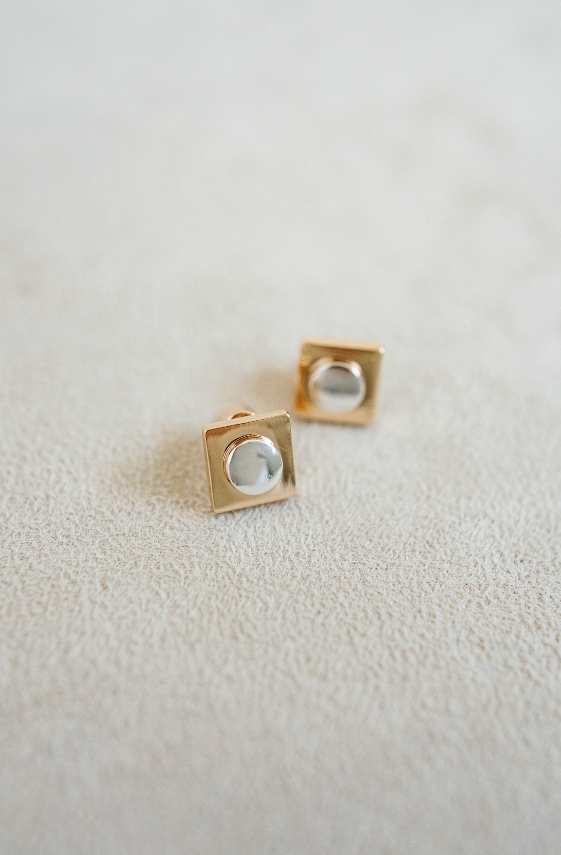 gold square stud with silver round center.