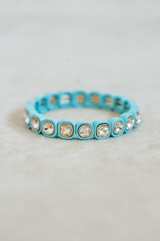 Petite enamel stretch bracelet. Adjusts to fit wrist with elastic band. Gold detail finish in blue.