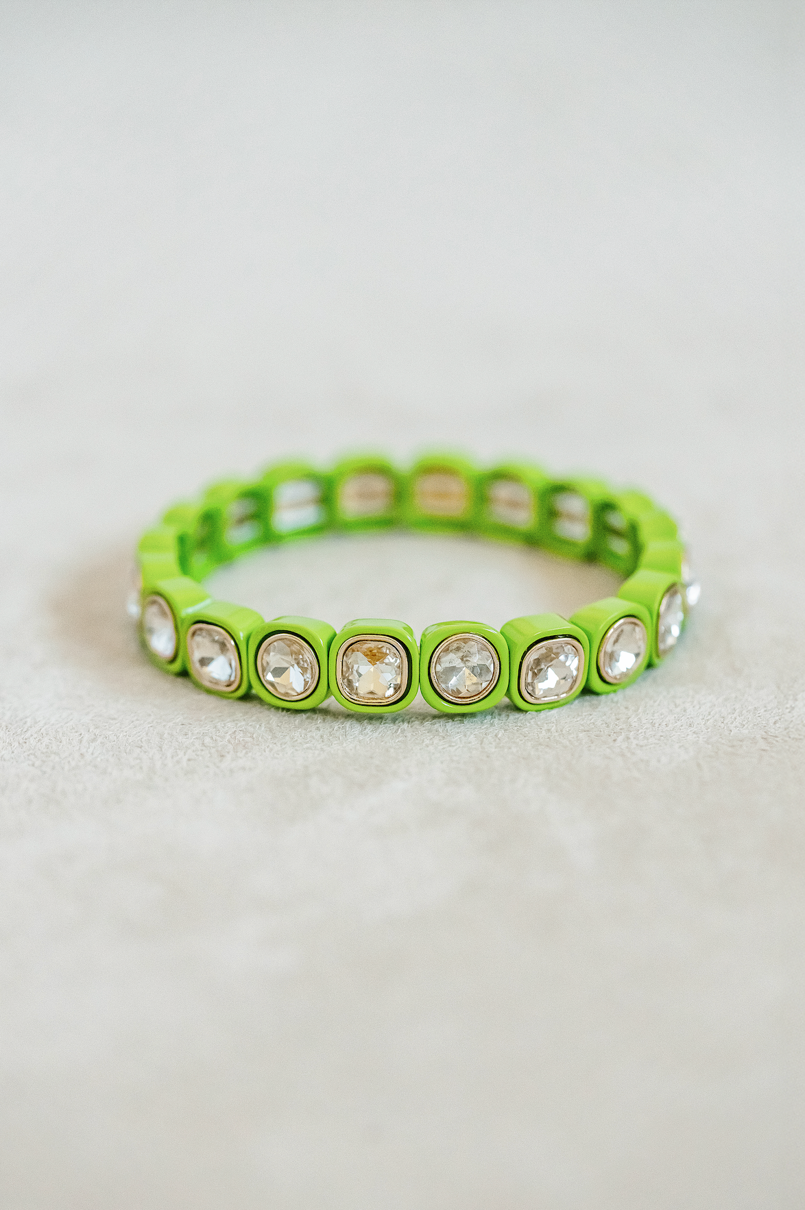 Petite, alternating enamel stretch bracelet. Adjusts to fit wrist with elastic band. Gold detail finish in limeade.