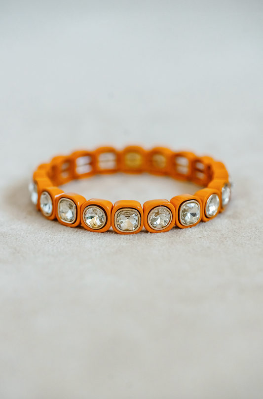 Petite, alternating enamel stretch bracelet. Adjusts to fit wrist with elastic band. Gold detail finish in orange.