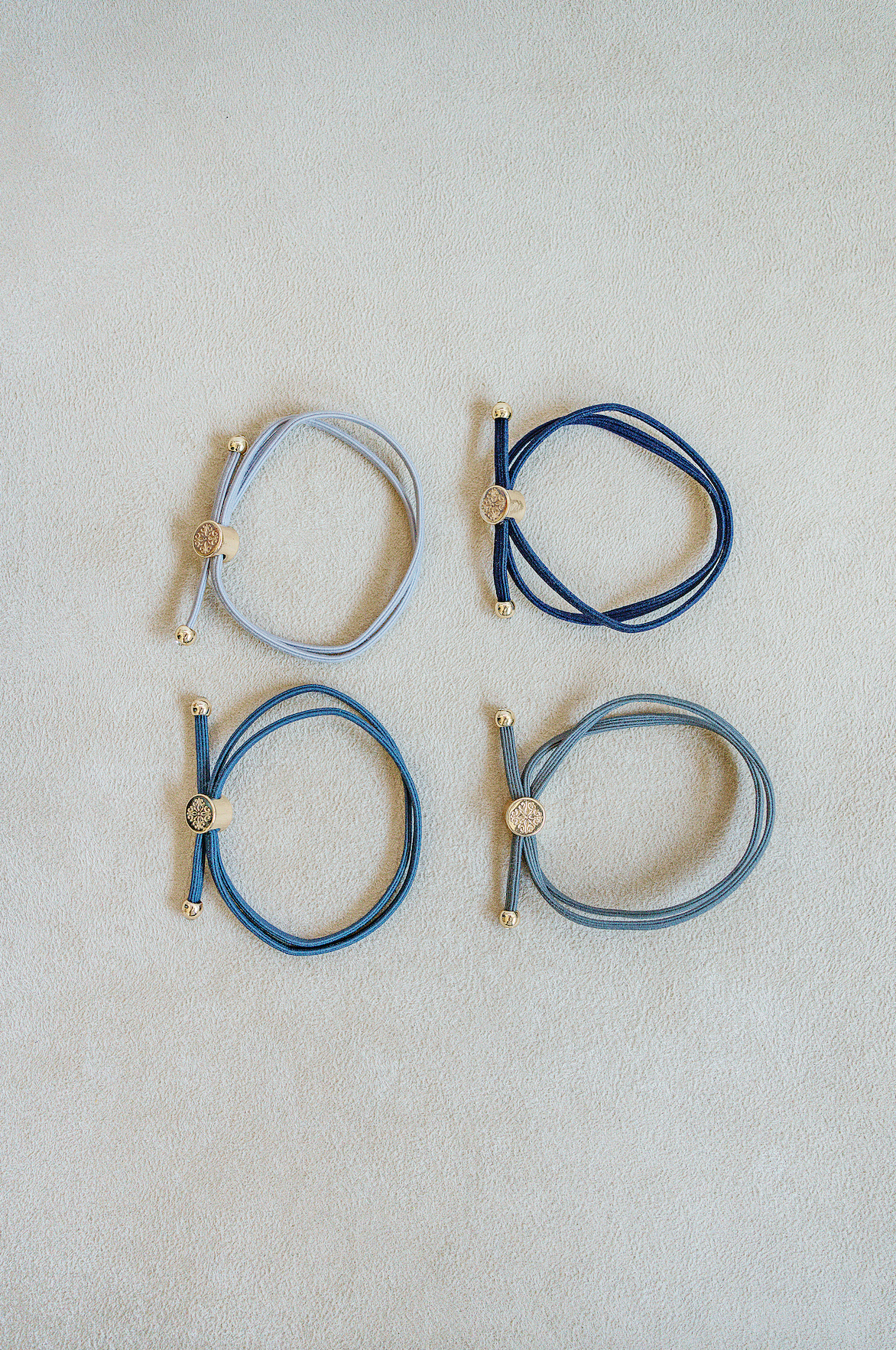 Sold as a set of 4, Skinny Hair Tie Set are double wrapped, minimal, sleek bracelets with round gold end caps and signature gold detail in Marine,