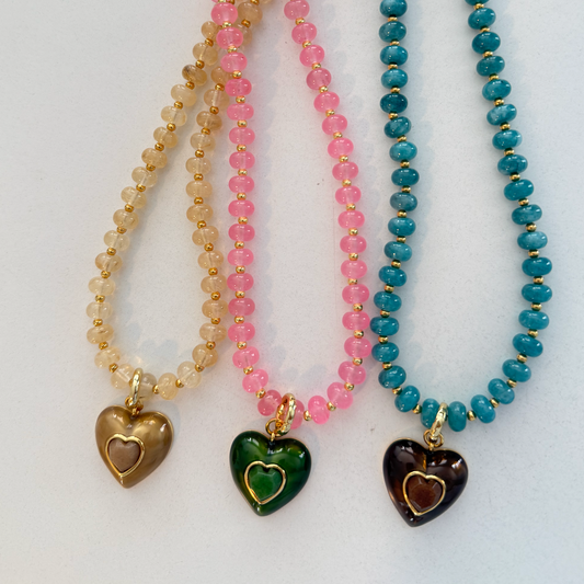 Three beaded necklaces with heart-shaped charms on a white background
