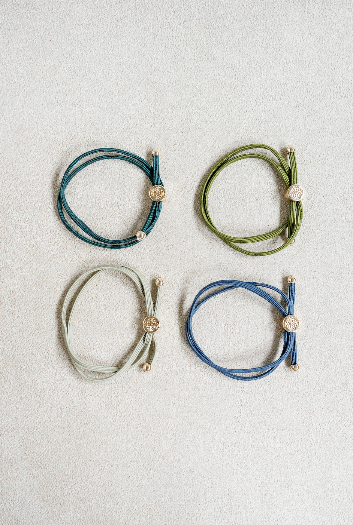 Skinny sleek hair tie set sold as a set of 4 with blue , steel blue , fern green , and moss green 