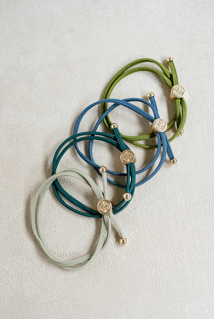 Skinny sleek hair tie set sold as a set of 4 with blue , steel blue , fern green , and moss green 