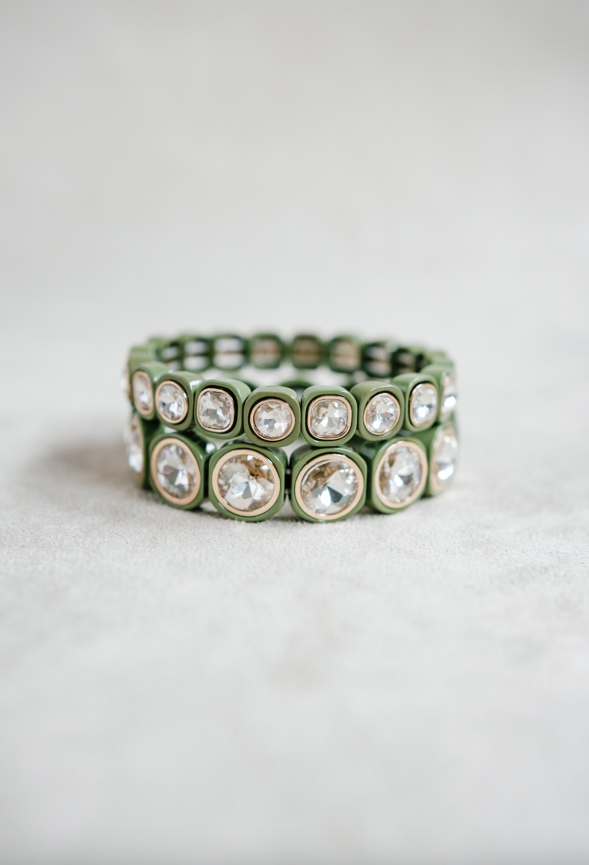 A minimalist bracelet featuring square olive-green acrylic beads, each set with sparkling crystal stones, arranged in a stretchy band design for easy wear. Round and petite bracelet stacked