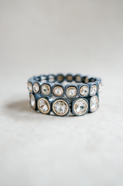 A chic stretch bracelet with dark gray square-shaped links, each adorned with faceted clear crystals framed in gold, offering an elegant, modern touch. petite and round bracelets