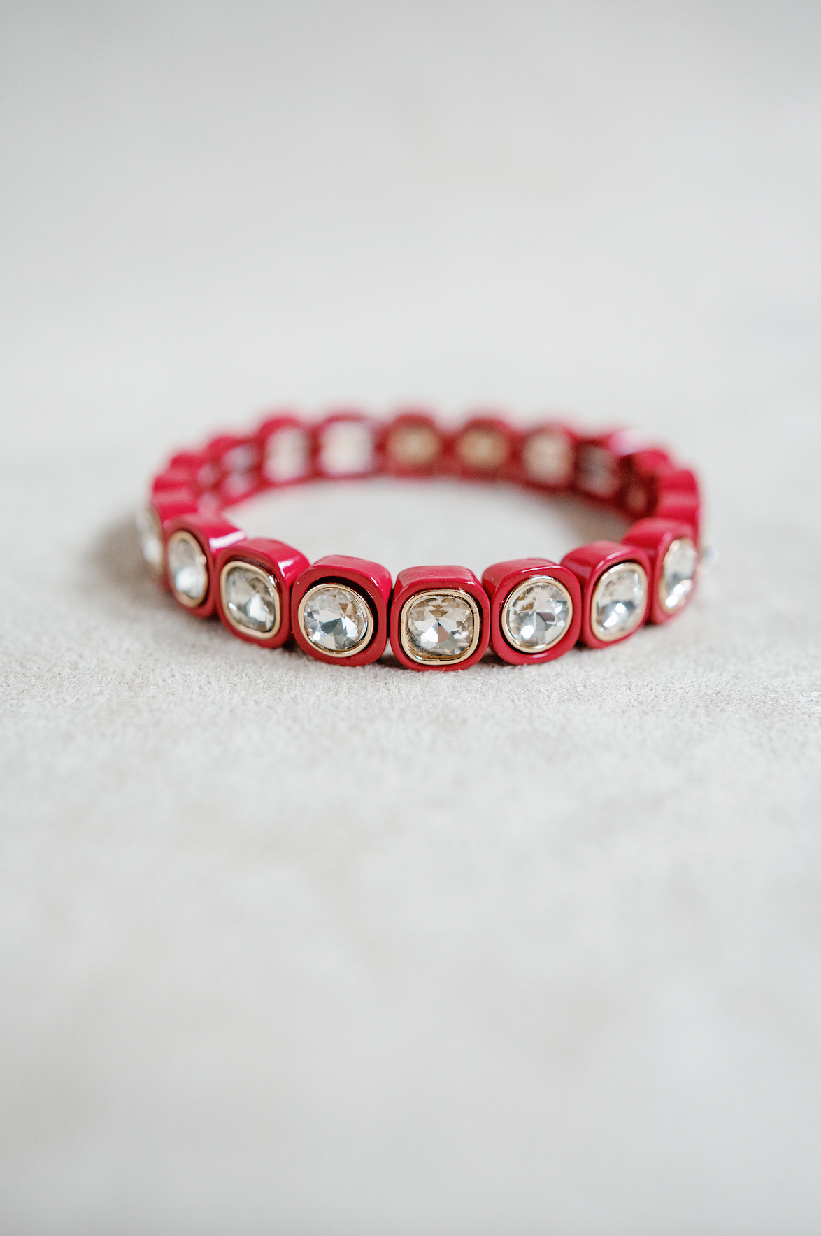 A scarlet red bracelet with square-cut crystals set in glossy, golf rounded frames, arranged in a stretchable band. petite size stretch bracelet.