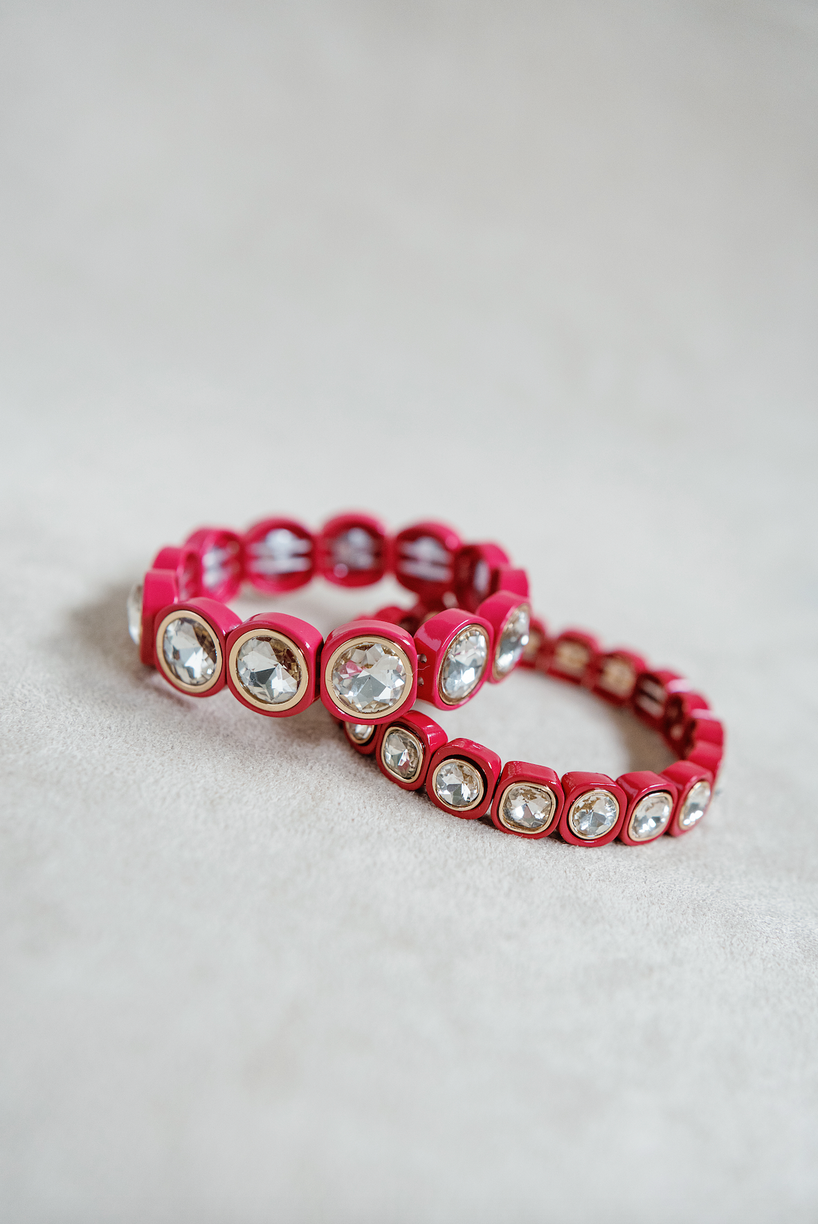 A scarlet red bracelet with square-cut crystals set in glossy, golf rounded frames, arranged in a stretchable band. Petite and Round stretch bracelet.