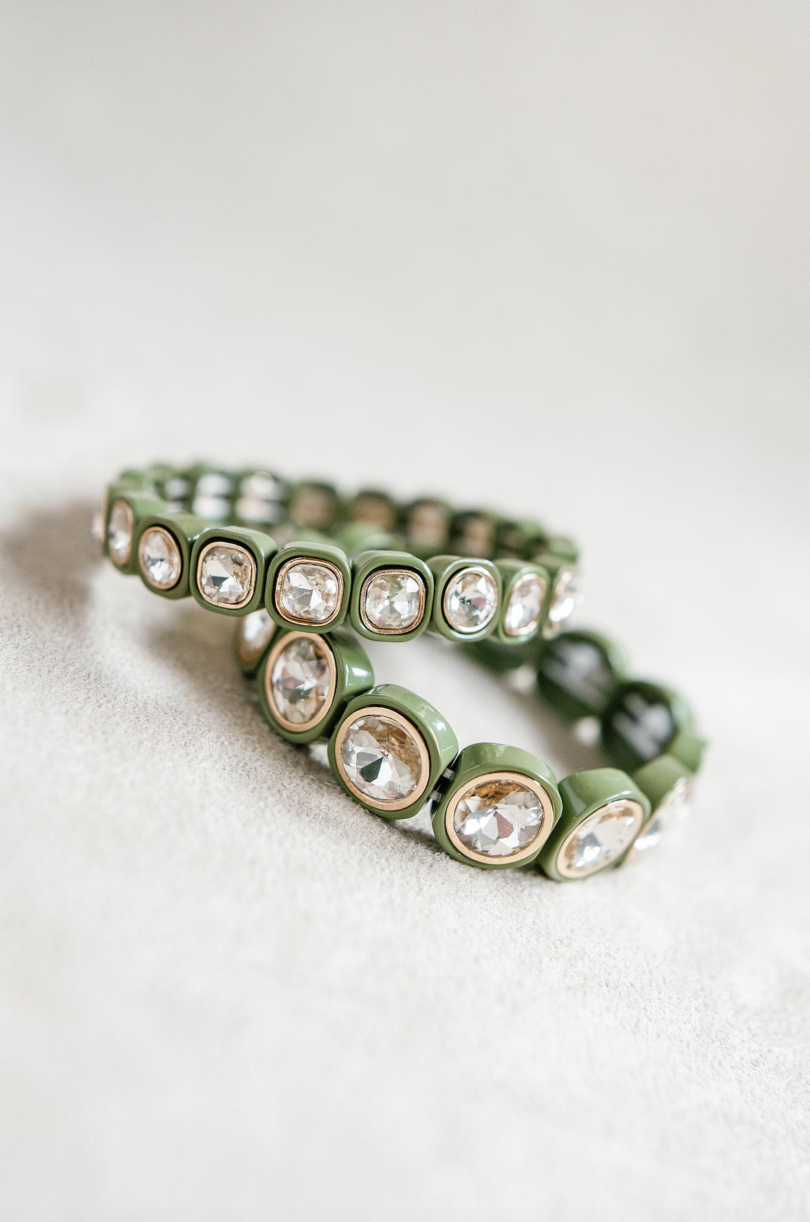 A minimalist bracelet featuring square olive-green acrylic beads, each set with sparkling crystal stones, arranged in a stretchy band design for easy wear. Round and petite bracelet stacked