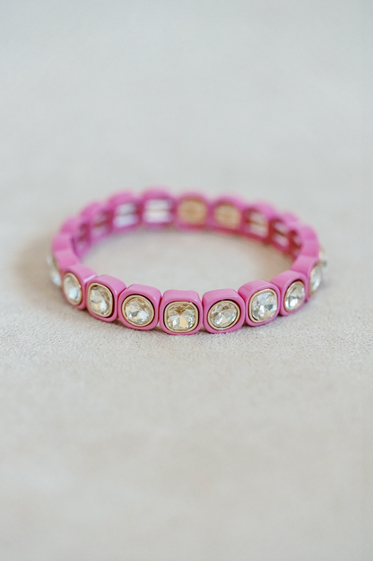 Petite, alternating enamel stretch bracelet. Adjusts to fit wrist with elastic band. Gold detail finish in raspberry pink.