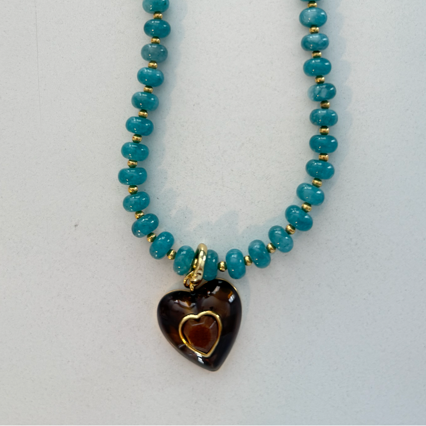 Necklace with blue beads and a heart-shaped pendant on a white background