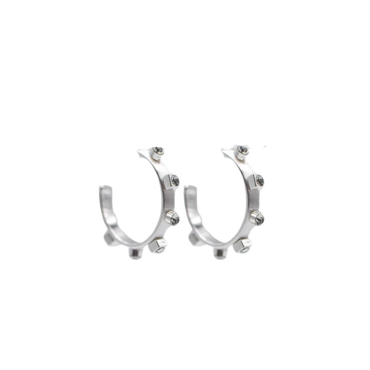 A pair of brushed silver metal hoop earrings with six silver studs and crystal jewel accents, set against a white background.