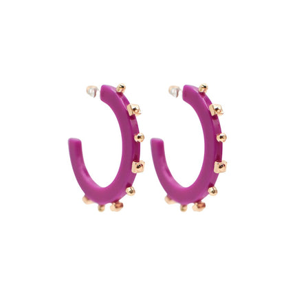 Large vibrant purple open hoop earrings featuring gold-tone studs along the outer edge, with a sleek design and clear post backings for comfortable wear.